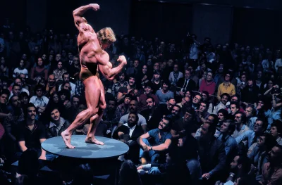 starnak - Arnold Schwarzenegger pozuje na stole przed dużym tłumem (1976) #arnoldschw...