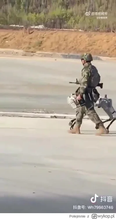 Polejmnie - Chiński żołnierz spacerujący ze swoim psem-robotem uzbrojonym w karabin m...