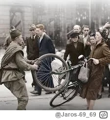 Jaros-69_69 - Żołnierz soviecki pomaga nieść rower kobiecie.