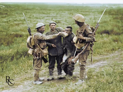 wojna - Brytyjski żołnierz daje rannemu niemieckiemu więźniowi trochę wody do picia p...