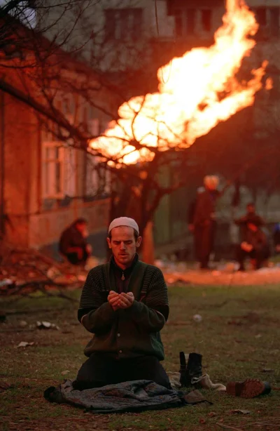 myrmekochoria - Czeczen modli się podczas bitwy o Grozny, styczeń 1995. Ogień ponoć ś...