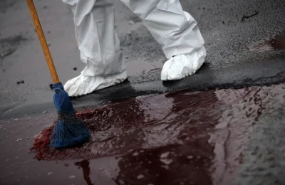 myrmekochoria - Pracownik policji zmiata krew do kanałów w Monterrey, 8 lutego 2012 r...