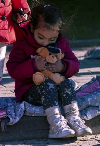 Jabby - Dziewczynka na tym dość znanym już zdjęciu trzyma misia. Na czapce jest napis...