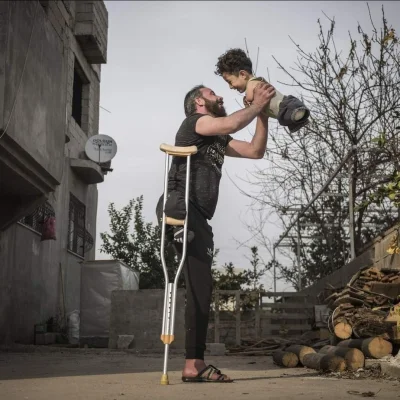 myrmekochoria - Syryjczyk ze swoim synem. Ojciec stracił nogę w nalocie, a dziecko ur...