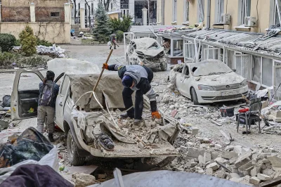 daniel-dadas - Ludzie usuwają gruzy przed zniszczonym budynkiem administracji regiona...