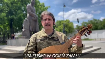 JPRW - Ukraiński żołnierz-bandurysta śpiewa "Pierwszą brygadę" pod pomnikiem Piłsudsk...