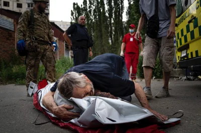 A.....n - Charków, 7 lipca. Mężczyzna przytula swoją zmarłą żonę po kolejnym rosyjski...