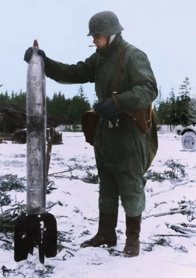 wojna - Niemiecki żołnierz trzyma pocisk M-13 kalibru 132 mm z radzieckiej wyrzutni p...