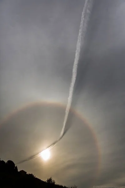 s.....w - Smuga kondensacyjna samolotu rzuca cień na chmury rozświetlone przez słonec...