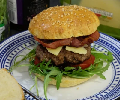 tptak - Burger z chutney z czerwonej cebuli, rukolą, cheddarem i boczkiem. Domowe buł...