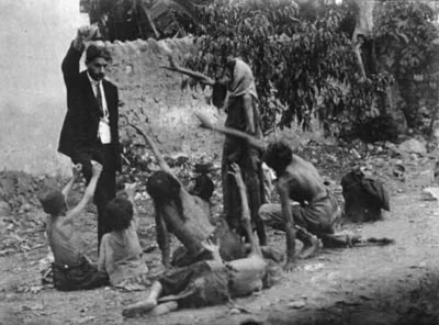 brusilow12 - Turecki urzędnik drażni się z głodującymi ormiańskimi dziećmi, pokazując...