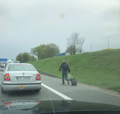 endryoou - Zdjęcie przedstawia pasażera, który idzie autostradową obwodnicą Krakowa n...
