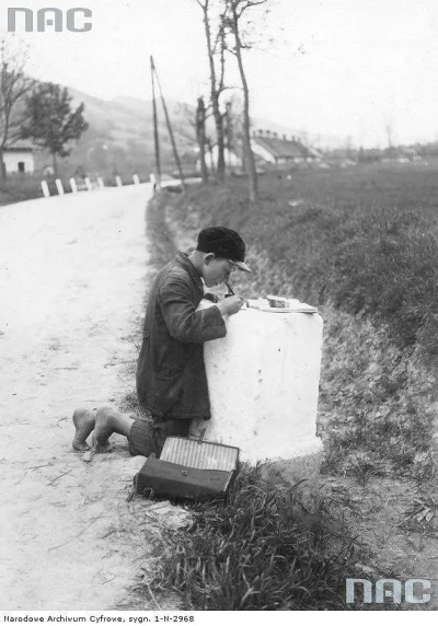 brusilow12 - Polski uczeń odrabia lekcje przy kamieniu kilometrowym, zdjęcie z 1931 r...