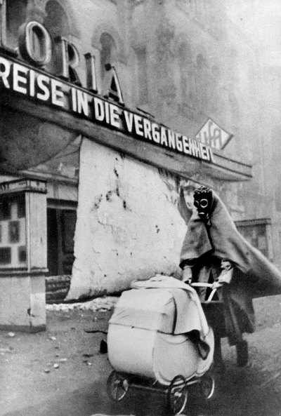 myrmekochoria - Kobieta w masce przeciwgazowej pcha wózek na ulicy Kurfürstendamm (Be...