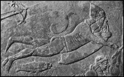 myrmekochoria - Detal z reliefu: asyryjski żołnierz przepływa rzekę na worku z owczej...