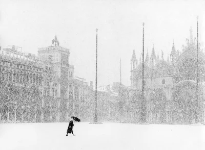 P.....f - 1932. Kobieta przechodzi przez płytę Rynku Głównego. W tle widzimy Sukienni...