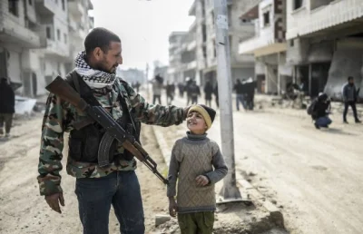 0.....1 - Kurdyjski żołnierz i jego syn w odbitym z rąk ISIS Kobane, 28 stycznia 2015...