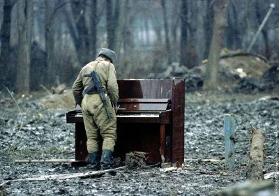A.....i - Rosyjski żołnierz - muzyk gra na pianinie w centrum zniszczonej stolicy Cze...