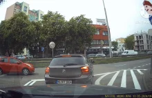 Pasażerka BMW gubi coś po otwarciu drzwi na skrzyżowaniu.