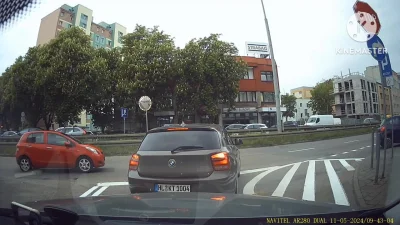 Pasażerka BMW gubi coś po otwarciu drzwi na skrzyżowaniu.