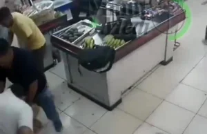 Kasjer sklepu wnerwiony biciem po głowie rzuca się na bandytę.