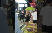 Beautiful Thai Girl hiding from rain