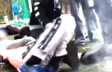 Grupa chłopców znęca się fizycznie nad jednym z równieśników na szkolnym boisku