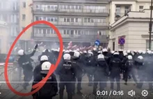 Prowokator policyjny rzuca kostką brukową w protestujących