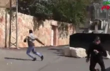 Izraelski buldożer spycha ogromne kamienie na Palestyńczyków.