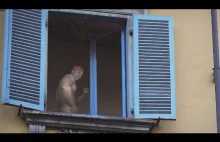 Tajemniczy, seksowny facet tańczy w oknie podczas szalejącej epidemii