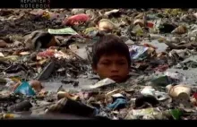 Dzieciak z Filipin zarabia na życie szukając w wodzie surowców wtórnych.