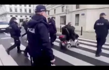 PIĘCIU policjantów eskortuje niepełnosprawnego do toalety