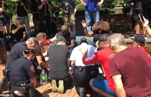 Biali policjanci klękneli przed czarną społecznością i zaczeli myć im nogi.