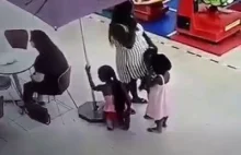 Matka z trójką dzieci na spacerze w centrum handlowym.