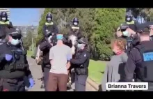 Australijska policja siłą nakłada ludziom maski.