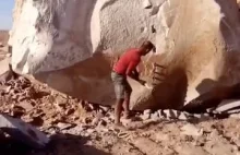 Mężczyzna łamiący wielką skałę