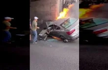 ludzie próbują wyciągnąć kierowcę z płonącego samochodu