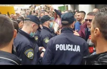Ludzie wygwizdują policję, która próbuje powstrzymać publiczne zgromadzenie.