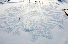 Finowie w rakietach śnieżnych tworzą dzieło sztuki na polu.