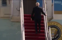 Joe Biden 3 razy przewraca sie wchodząc po schodach do samolotu