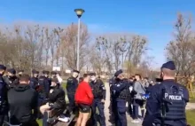 Policja w Białymstoku rozgania trening na świeżym powietrzu. Obok tłumny stragan