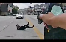 Policjant oddaje strzały do człowieka uzbrojonego w kartke papieru.