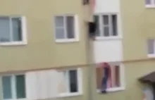 Rosyjscy przechodnie wyciągają trójkę dzieciaków z płonącego mieszkania