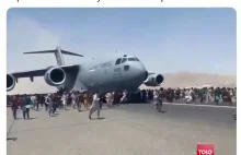 People run as a US military aircraft attempts to take off.