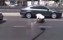 Muslim prowadzi modły na ulicy pełnej samochodów