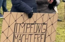 Plakaty z hasłem "Szczepienia czynią wolnym" na proteście w Niemczech