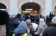 Rosyjska policja zatrzymuje starszą panią protestującą przeciwko wojnie.