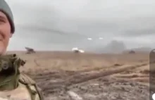 Uśmiechający się rosyjski żołnierz na tle prowadzonego nalotu rakietowego