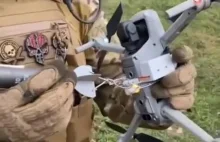 Ukraiński żołnierz pokazuje przygotowanie drona do ubijania orków