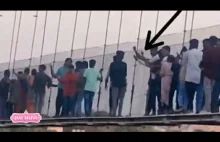 Wielu ludzi idących po moście, który się zawalił w Indiach próbuje go uszkodzić!